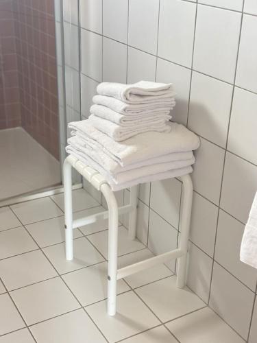 a pile of towels sitting on a stool in a bathroom at Domaine de Barthas in Castelnau-Magnoac