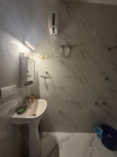 a white bathroom with a sink and a mirror at Roaming Rovers - Pet-Friendly & Peaceful Homestay in Almora in Almora