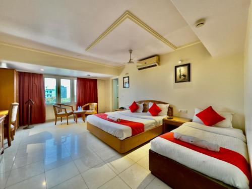 a hotel room with two beds and a table at KANCHAN DEEP in Jaipur