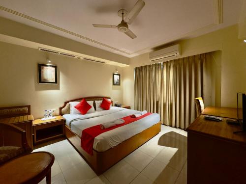 a bedroom with a large bed with red pillows at KANCHAN DEEP in Jaipur