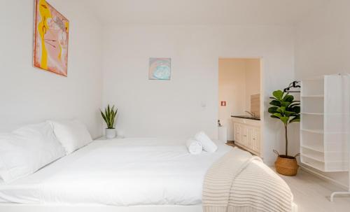 a white bedroom with a large white bed in it at PortoNest Downtown Suites in Porto