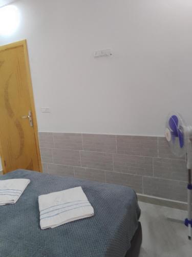 a room with a bed with two white towels on it at Chez Franck in Saïdia