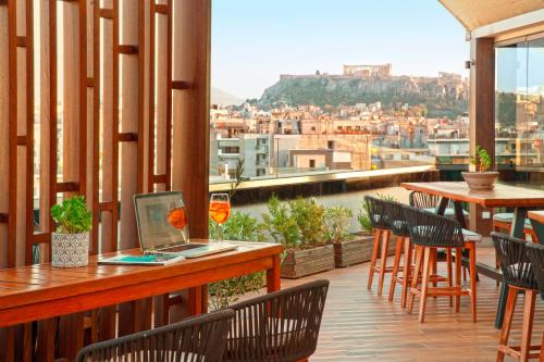 a balcony with a laptop on a table with chairs at Zeus Wyndham Grand Athens in Athens