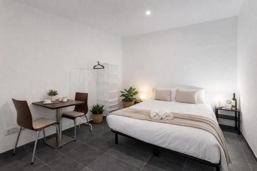 a bedroom with a bed and a table and chairs at PortoNest Downtown Suites in Porto