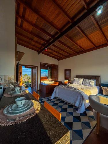 a bedroom with a bed and a living room at Chalés Mirante da Colina in Venda Nova do Imigrante