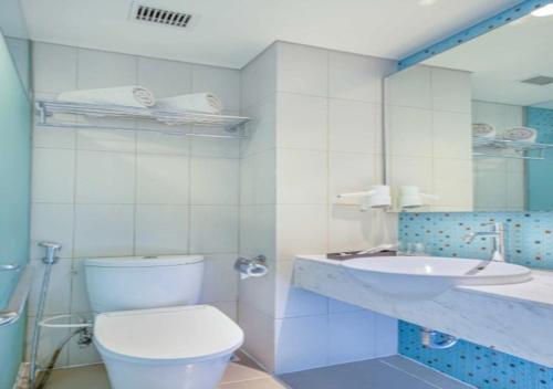 a white bathroom with a toilet and a sink at Asyana Pemuda Jakarta in Jakarta