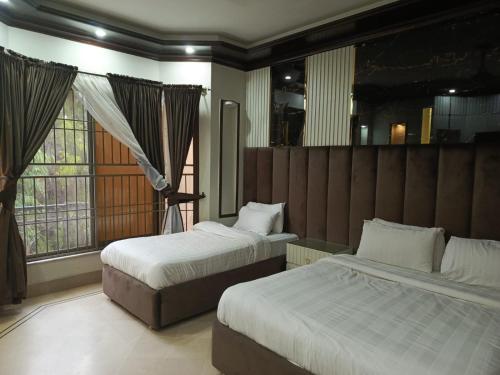 a hotel room with two beds and a window at Sonnet Inn Guest House in Dargai