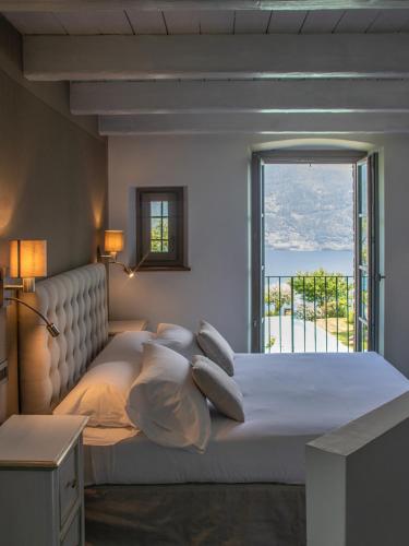 a bedroom with a large bed with a large window at Agriturismo Treterre in Pianello Del Lario