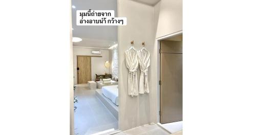 a room with a robe hanging on a wall at 24Rooms นครสวรรค์ in Nakhon Sawan