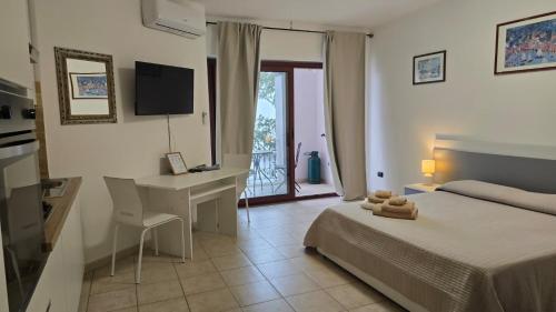 a bedroom with a bed and a desk and a computer at Open space centrale con parcheggio privato coperto in Palau
