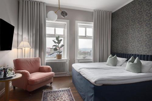 a bedroom with a bed and a chair and a window at Grand Hotel Jonkoping, BW Signature Collection in Jönköping