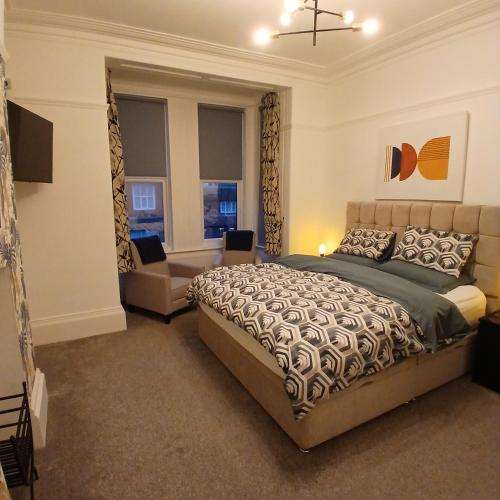 a bedroom with a bed and a couch and a window at Bagshaw Bed & Breakfast in Bridlington