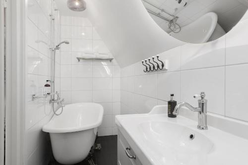 a white bathroom with a sink and a mirror at Grand Hotel Jonkoping, BW Signature Collection in Jönköping
