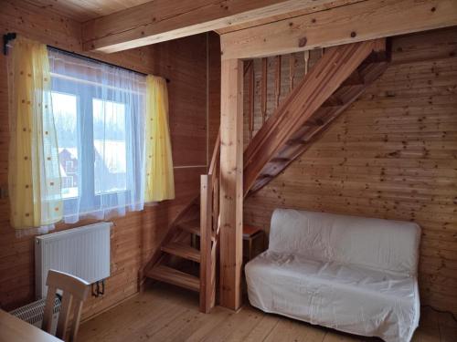 a bedroom with a bunk bed in a log cabin at Roubenka pod Čerťákem in Dolní Moravice