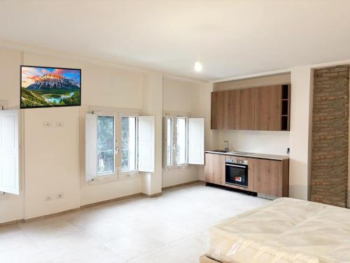 a room with a bed and a kitchen with windows at Ugo Bassi 98 in Cento