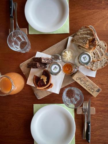 ein Tisch mit Tellern voller Speisen und Gläsern Wein in der Unterkunft Cascina Bagaggera in Rovagnate
