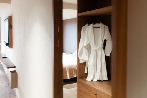 a white robe is hanging in a closet at Le Relais D'Orti in Sainte-Ode