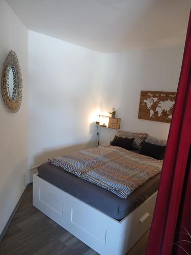 a bed in a bedroom with a red curtain at Kleine Auszeit in Möhnesee