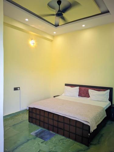 a bedroom with a bed with a ceiling fan at Hotel Pleasure Inn in Prayagraj