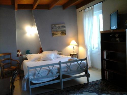 a bedroom with a bed and a window at LES Roses Trémières in Gémozac