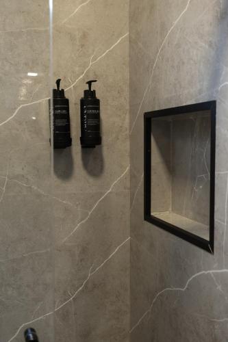 a bathroom with two shampoo bottles on the wall at Pousada Du Valle in Embu