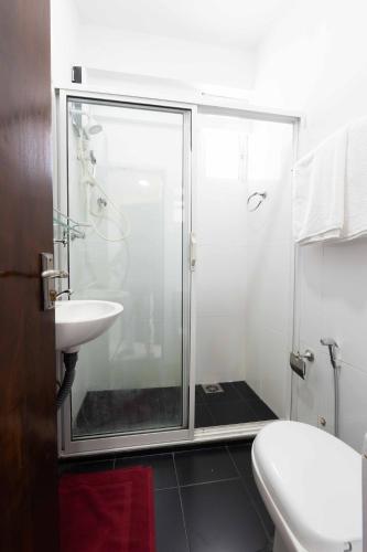 a bathroom with a shower and a toilet and a sink at Urban Kandy City Hotel in Kandy