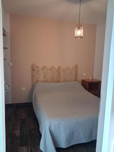 a bedroom with a bed with a wooden headboard at Maison du causse in Magalas