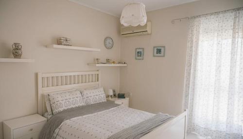 a white bedroom with a bed and a window at Spacious Residence in Rafina with Panoramic Views in Rafina