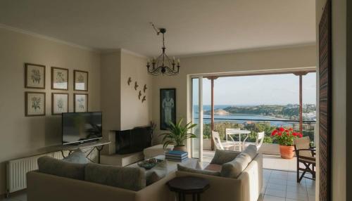 a living room with couches and a television and a view at Spacious Residence in Rafina with Panoramic Views in Rafina
