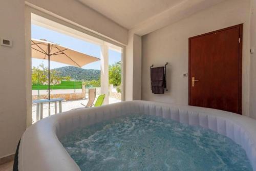 a bath tub in a room with a large window at Holiday Home Vala in Vinišće