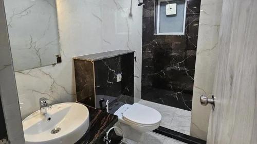 a bathroom with a white toilet and a sink at Iconic Studio Apartment in Jaipur in Jaipur