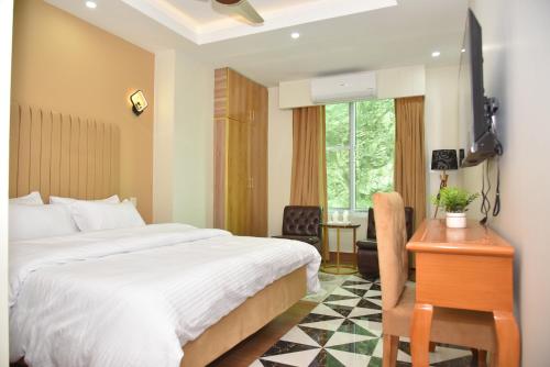a bedroom with a bed and a desk and a chair at Luxury Stay Near Neelum River Valley,208 in Muzaffarabad