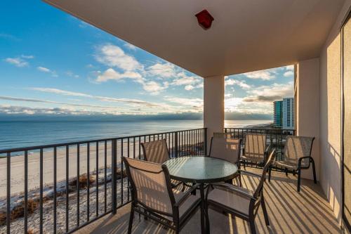 a balcony with a table and chairs and the ocean at Phoenix X 609 condo in Orange Beach