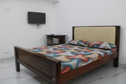 a bed with a colorful comforter in a room at Anand Classic in Thiruchendur
