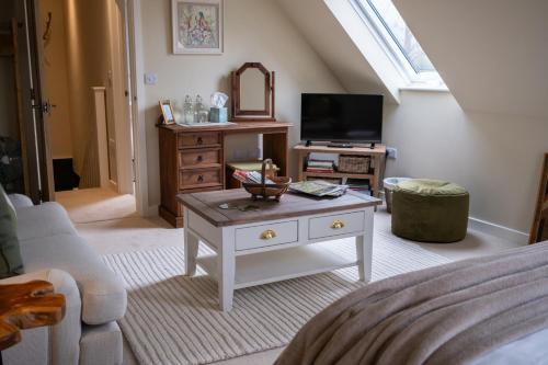 a living room with a coffee table and a tv at Roost in Heyshott in Midhurst