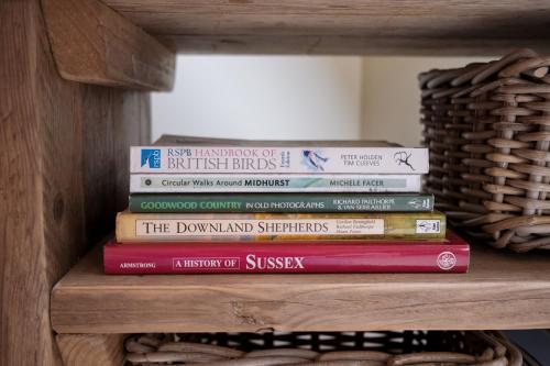 a stack of books sitting on a shelf at Roost in Heyshott in Midhurst