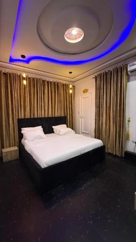 Ein Schlafzimmer mit einem großen weißen Bett und blauer Decke in der Unterkunft ZAPHOMEs in Asaba
