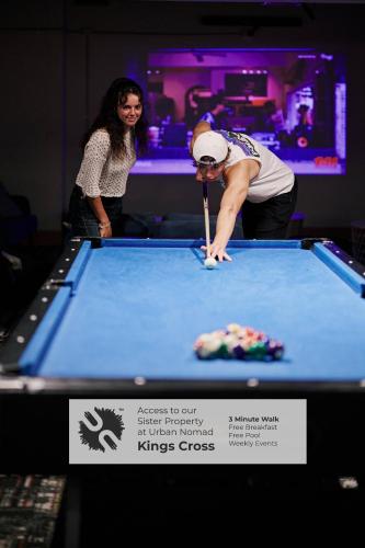 a woman playing pool in a pool table at Urban Nomad Potts Point - 18 to 39 only in Sydney