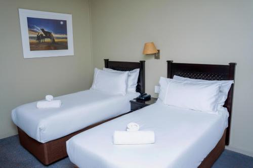 a hotel room with two beds and a picture on the wall at Q's Evander Hotel & Apartments in Evander