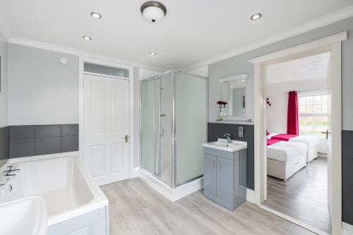 a bathroom with a tub and a sink and a bedroom at The Railway Sleeper Lodge in Colchester