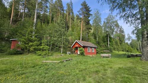 a small red cabin in the middle of a field at Cozy Off-Grid Cabin - No Power, No Running Water in Skretteberg