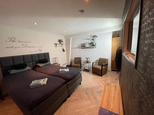 a bedroom with a bed and a living room at B&B Molenhuiszuilichem in Zuilichem