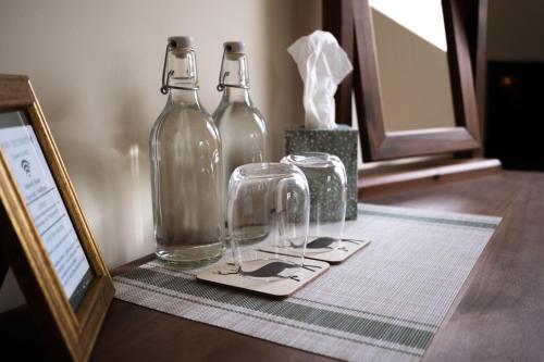 two glass bottles sitting on top of a table at Roost in Heyshott in Midhurst
