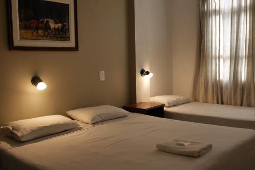 a room with two beds and a picture on the wall at PASEO GüEMES HOTEL in Salta