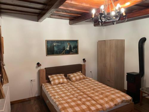 a bedroom with a bed and a painting on the wall at Ádi Vendégház - Bekecs in Bekecs