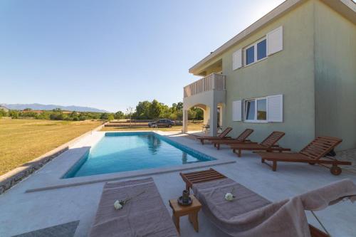 a villa with a swimming pool and a house at Villa Green Oasis in Lovreć