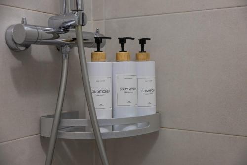 a shelf in a bathroom with four bottles on it at Casetta in Via Dini in Padova