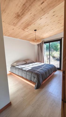 a large bed in a room with a large window at Aire in La Estancia