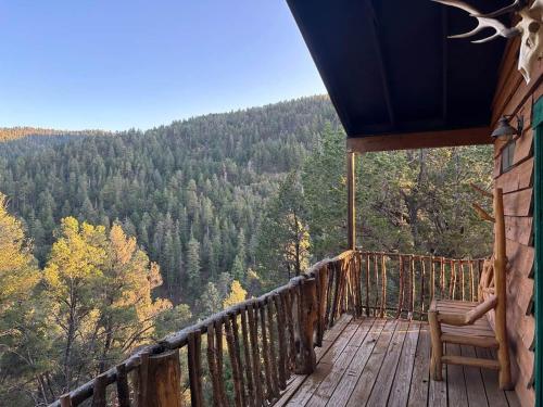 a balcony of a cabin with a view of the forest at Skyline Ranch in High Rolls