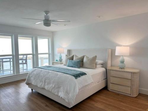 a white bedroom with a bed and a ceiling fan at Blue Heron Hideaway in Rockport